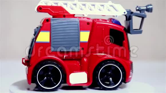 红色玩具消防车鳞片模型车在白色背景上旋转视频的预览图