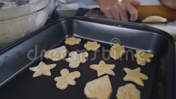 烤盘上有糖霜的原始形状饼干女人正在用面粉做姜饼面团把生饼干穿上视频的预览图