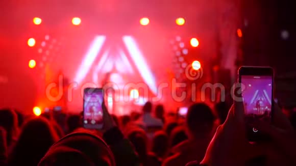 夜晚的生活歌迷们在摇滚音乐会上用智能手机拍照现场很亮视频的预览图
