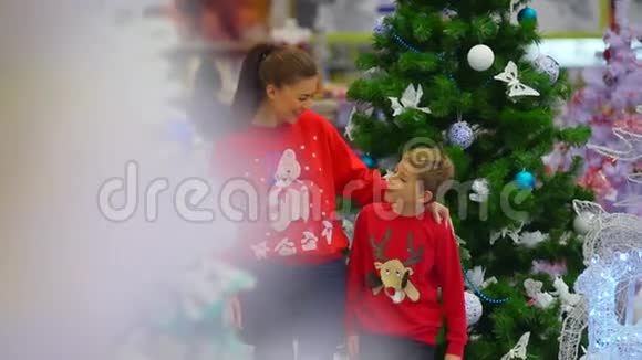 准备圣诞节妈妈和儿子在购物中心散步看看寒假装饰和其他东西视频的预览图