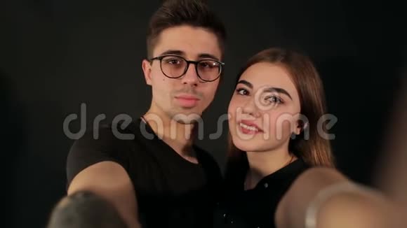 快乐的时髦情侣在黑色上自拍视频的预览图