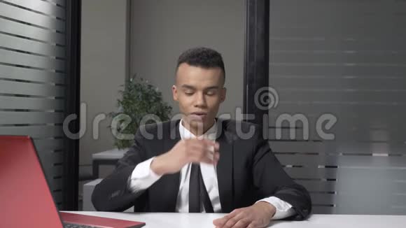 年轻成功的非洲商人穿着一套显示失望情绪的西装坐在办公室里60视频的预览图