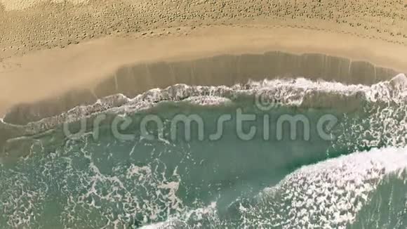 从上到下可以看到沙滩上有许多脚印的海浪视频的预览图