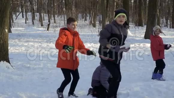 四个弟弟在冬季公园里慢动作玩雪球视频的预览图