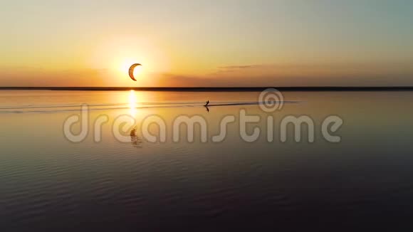 湖边夕阳西下一个孤独的风筝爱好者骑着它视频的预览图