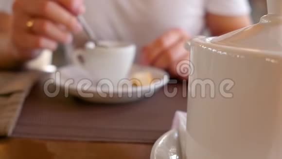 人手捧一杯茶喝桌上的一杯茶近距离射击视频的预览图