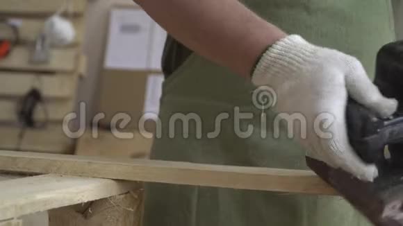 由天然木材制成的产品并在其上工作与木结构和磨床一起工作戴白手套的大师视频的预览图
