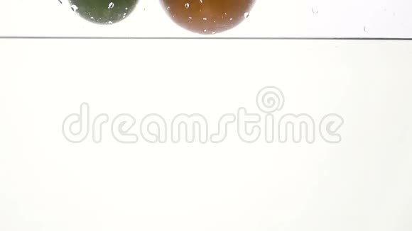 新鲜多汁的热带水果在清冷的水中落下并溅到白色物体上的特写慢镜头视频的预览图