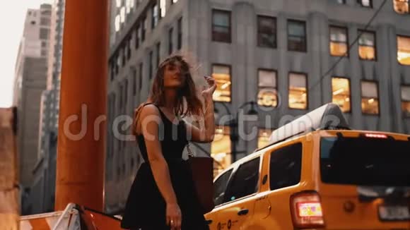 年轻漂亮的女人站在美国纽约的交通道路附近购物后等待出租车视频的预览图