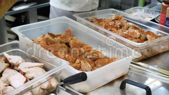 餐厅厨房的烹饪过程中厨师戴着蓝色手套用香料姜黄胡椒腌制肉视频的预览图