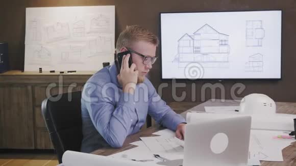 建筑师在办公室工作时用手机说话视频的预览图