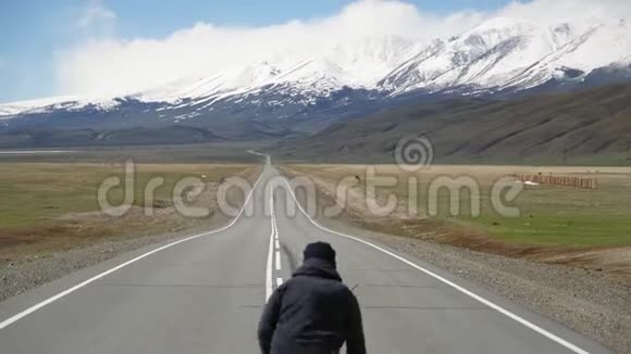 年轻人骑着长绳或滑板走在美丽的山谷里视频的预览图