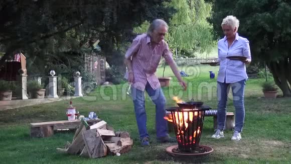 那人在篝火旁用煎锅煎炸的煎蛋招待妻子视频的预览图
