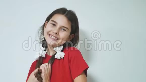 害羞的小笑着快乐的女孩站着可爱的少女快乐的女孩在白色背景下害羞情感是大孩子视频的预览图