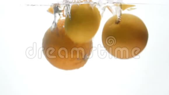 白色背景下多汁成熟的柑橘类水果落入水中的慢镜头视频的预览图