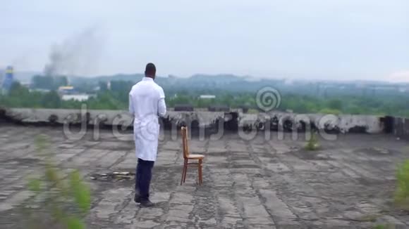 这位年轻的非洲医生正坐在医院的屋顶上在医院的背景下这本书视频的预览图
