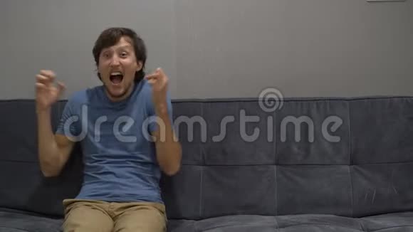一个年轻人坐在沙发上感到压力和愤怒右侧复制空间视频的预览图
