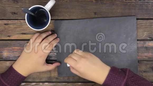 俯视图一个人用粉笔在黑板上写单词菜单视频的预览图