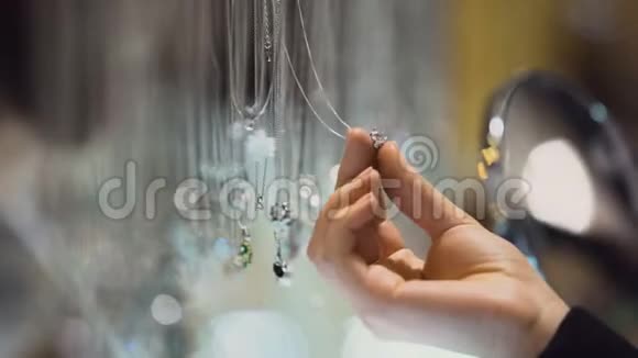 女性买家手里拿着宝石吊坠昂贵的珠宝展览购买视频的预览图