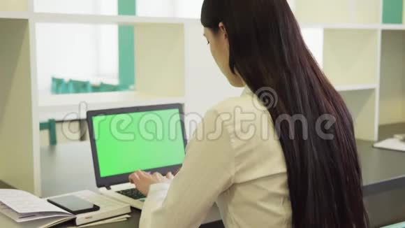 女人用绿色屏幕的笔记本电脑视频的预览图