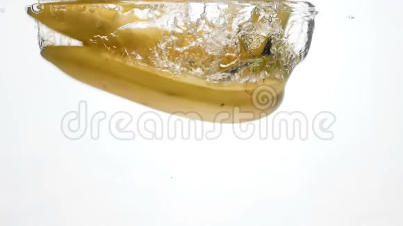 新鲜成熟的香蕉在白色背景下落入水中的慢镜头空气中的气泡漂浮视频的预览图