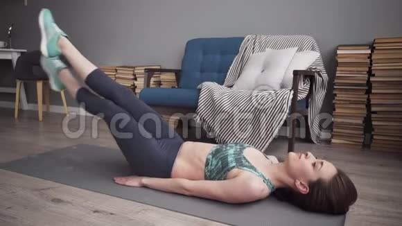 健身妇女在家中为核心肌肉做腿部运动视频的预览图