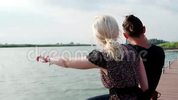 快乐的一对情侣在湖边用平板电脑拍摄精彩的景色视频的预览图