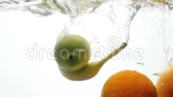 白色背景下热带水果在水中落下和溅落的模糊慢动作视频视频的预览图