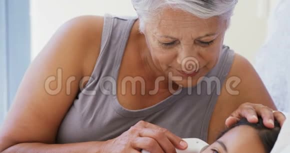 外婆在4k床房检查生病孙女的体温视频的预览图
