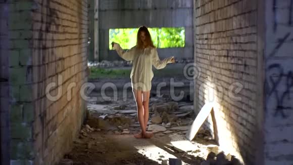 那个穿着白色衬衫的神秘女人在这座被毁的老建筑里奇怪地移动着双手视频的预览图