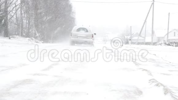 他的汽车沿着雪道行驶冬天和强烈的暴风雪视频的预览图
