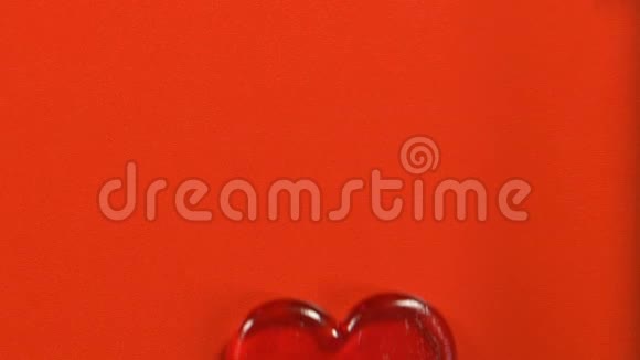 红色背景上分离的心形棒棒糖情人节符号顶部视图视频的预览图