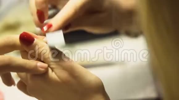 女性美容师用档案塑造顾客指甲水疗中心服务抛光视频的预览图