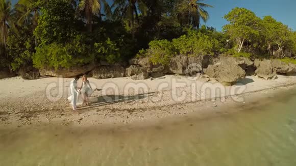 新婚夫妇很高兴跑进大海鸟瞰博霍尔海岸岛空中飞行菲什耶景色菲律宾视频的预览图