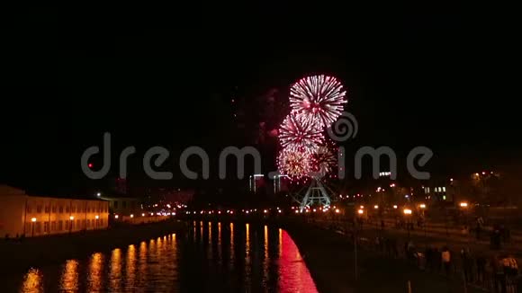 光明美丽的烟花在城市的堤岸上在夜空的摩天轮的背景下是视频的预览图