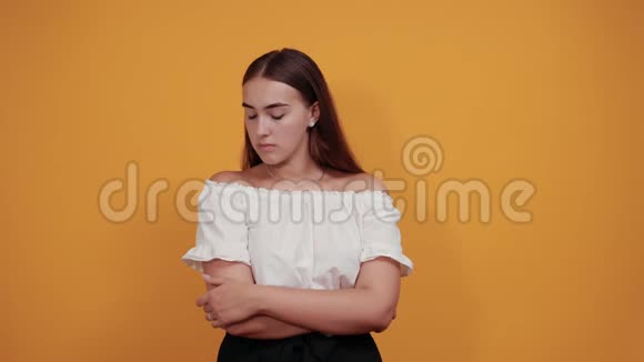 有魅力的年轻女子手托着下巴想着橙色墙上的问题视频的预览图