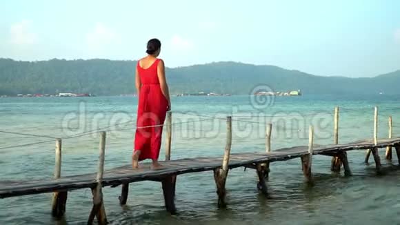 两个视频镜头PhuQuoc岛那个女人用伸直的手在码头上花钱女人看着打开的视频的预览图