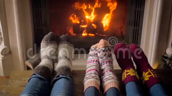 客厅壁炉旁穿针织袜子的年轻家庭慢动作视频视频的预览图