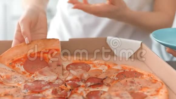 年轻的幸福夫妇打开盒子把披萨放进盘子里视频的预览图