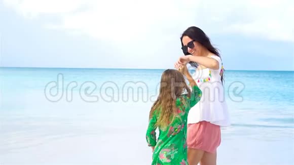 美丽的妈妈和加勒比海滩上的小女儿一起玩流动人口视频的预览图