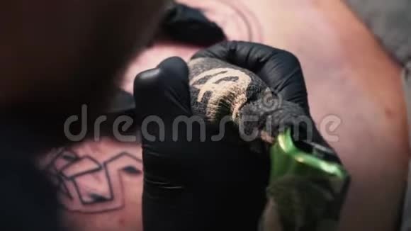 乌克兰基辅2018年5月20日为顾客做纹身的艺术家的手戴着黑色手套的纹身艺术家做纹身视频的预览图