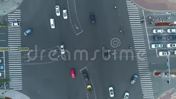 空中无人机在城市的十字路口汽车和公共汽车在大道上行驶日落时分镜头向上移动视频的预览图