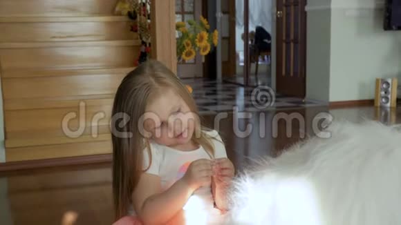 可爱的小女孩坐在家里地板上的软玩具上视频的预览图