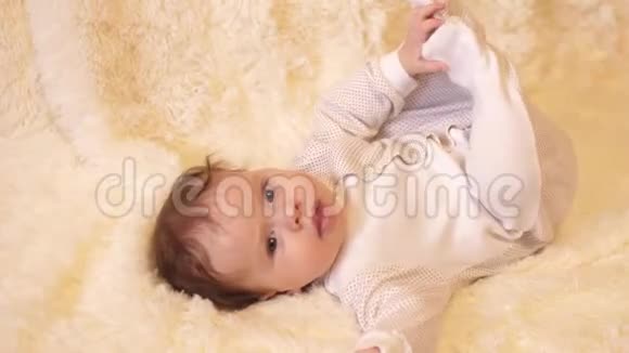 身体里的婴儿躺在他的背上玩他的手腿和说话视频的预览图