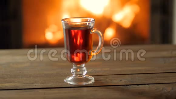 特写4k镜头年轻女子穿着毛衣在燃烧的壁炉旁喝热茶视频的预览图