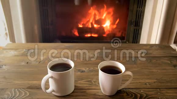 特写4k镜头情侣们从壁炉旁的木桌上拿着热茶杯子视频的预览图