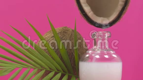 在玻璃瓶中倒入椰子奶身体和头发护理化妆品提取物视频的预览图