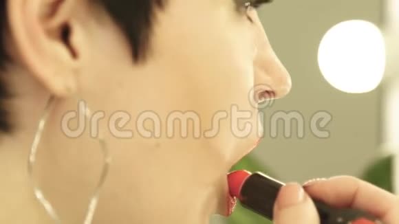 闭上脸女人化妆用红色口红涂嘴唇漂亮的女人涂红唇膏性感视频的预览图