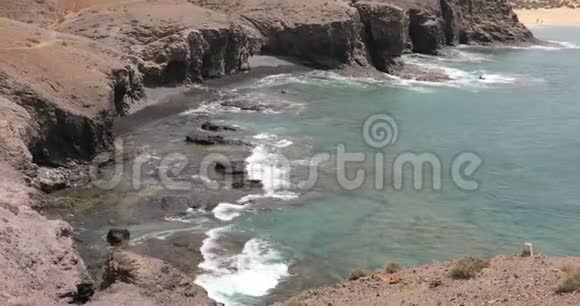 大西洋海浪在岩石海岸和黑沙在普拉亚斯帕帕加约海滩兰萨罗特视频的预览图