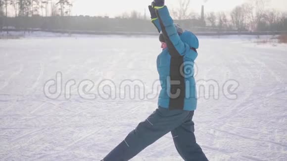 在冬季公园做运动的青少年冬天在户外做体操健康生活方式视频的预览图